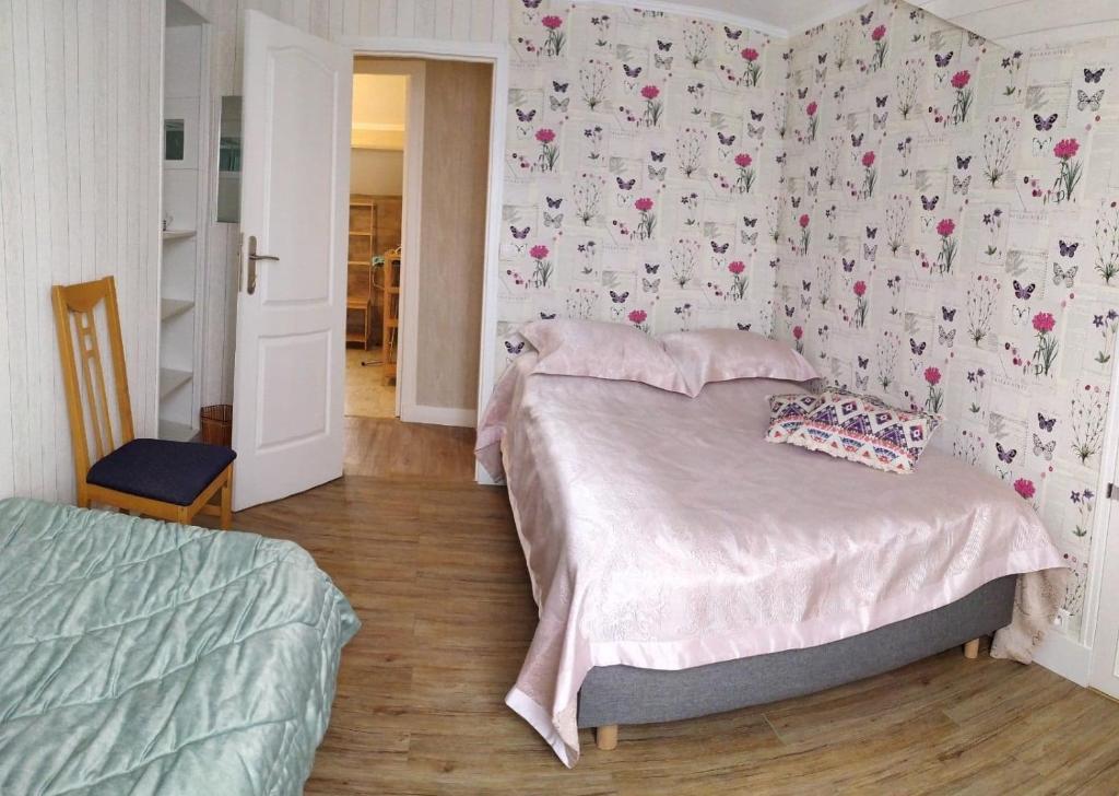 1 dormitorio con 1 cama y una pared cubierta de flores en SOL'ANGE Maison d'Hotes, en Clamart