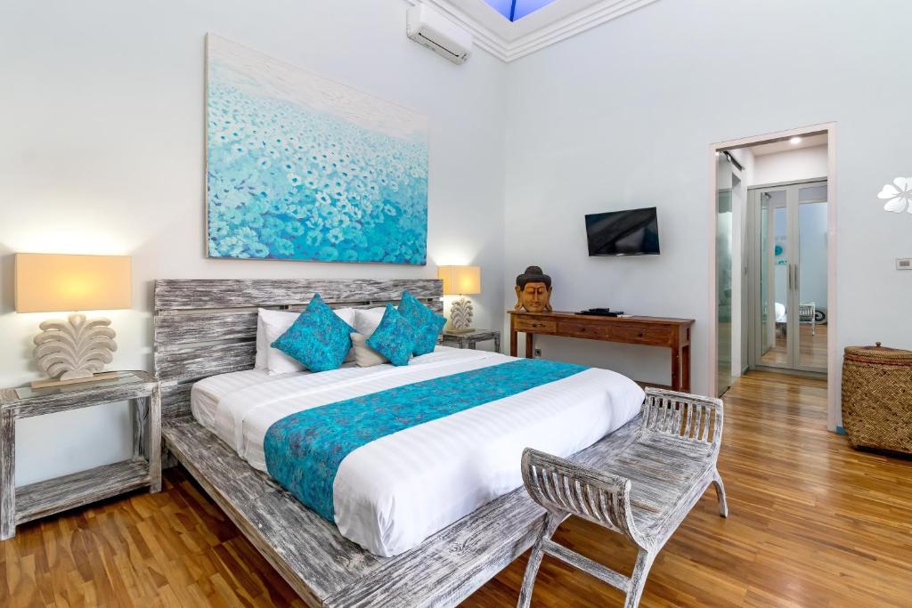 沙努爾的住宿－普拉別墅，一间卧室配有一张带蓝色枕头的大床
