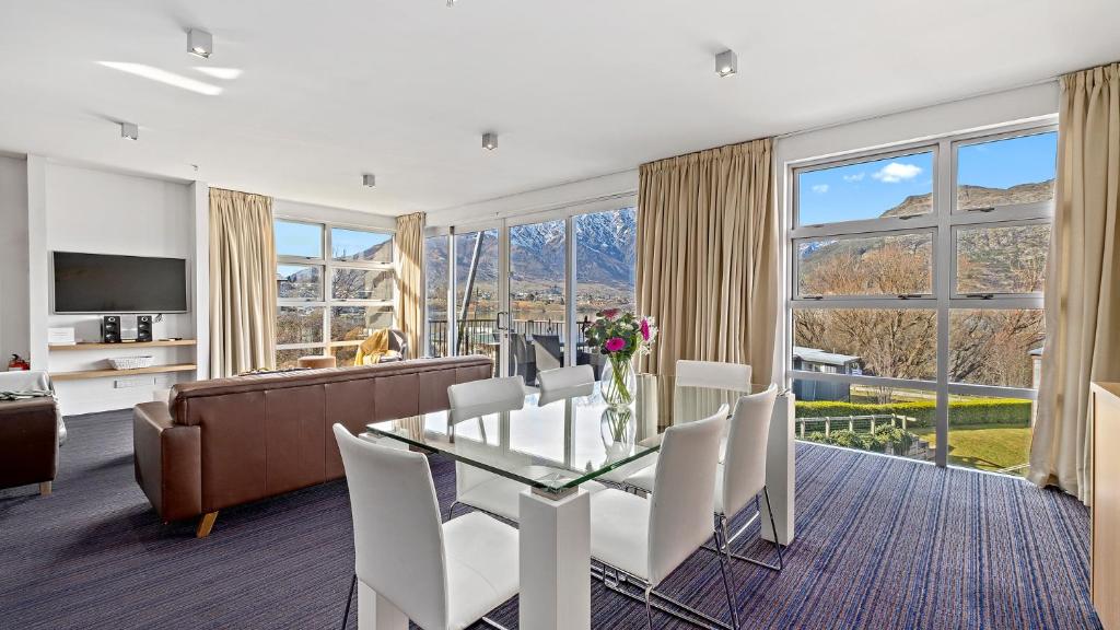 a living room with a table and chairs and a couch at Marina Apartment 406 in Queenstown