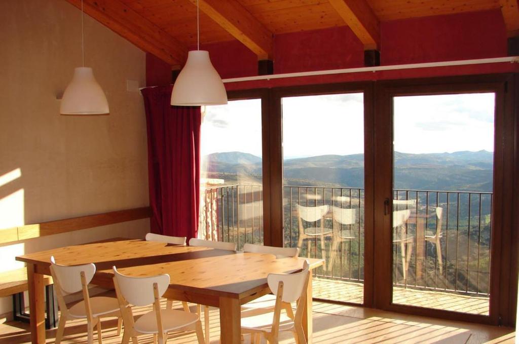 a dining room with a table and chairs and a balcony at Casa Rural Virginia in Ares del Maestre