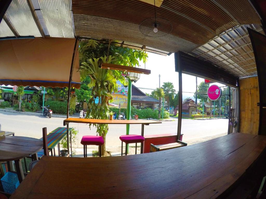 een restaurant met een bar met krukken en een tafel met planten bij Payi Resort in Pai