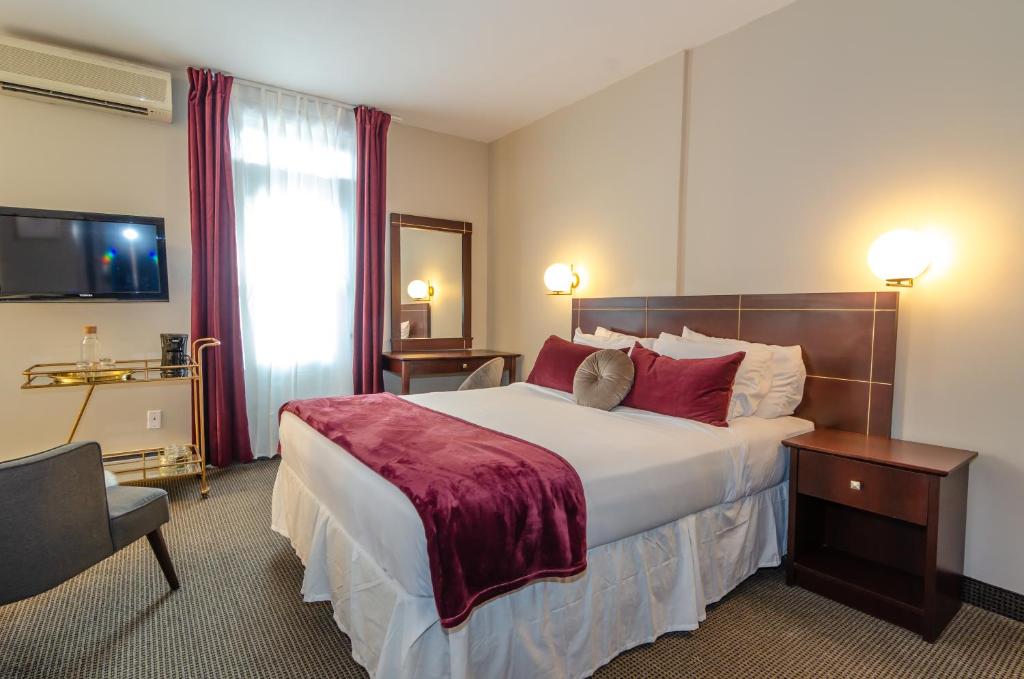 a hotel room with a large bed with red pillows at Maison Cartier Montreal in Montreal