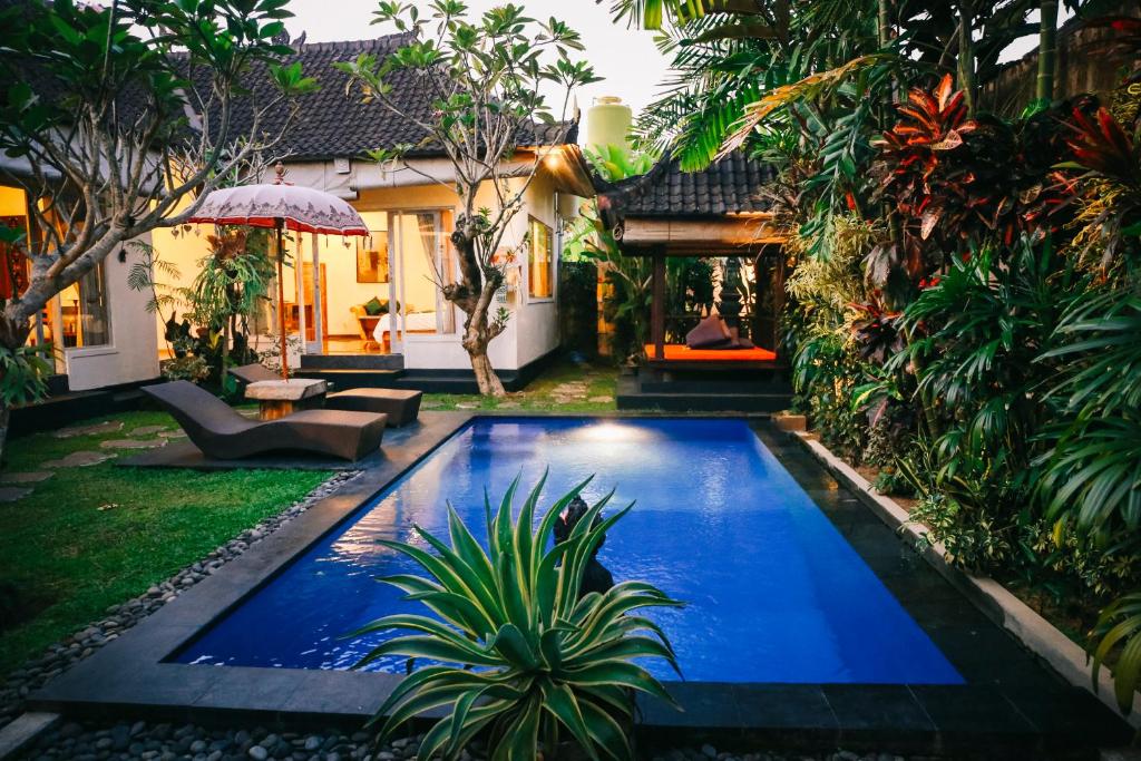 a swimming pool in the yard of a house at Rumah Karda Ubud in Ubud