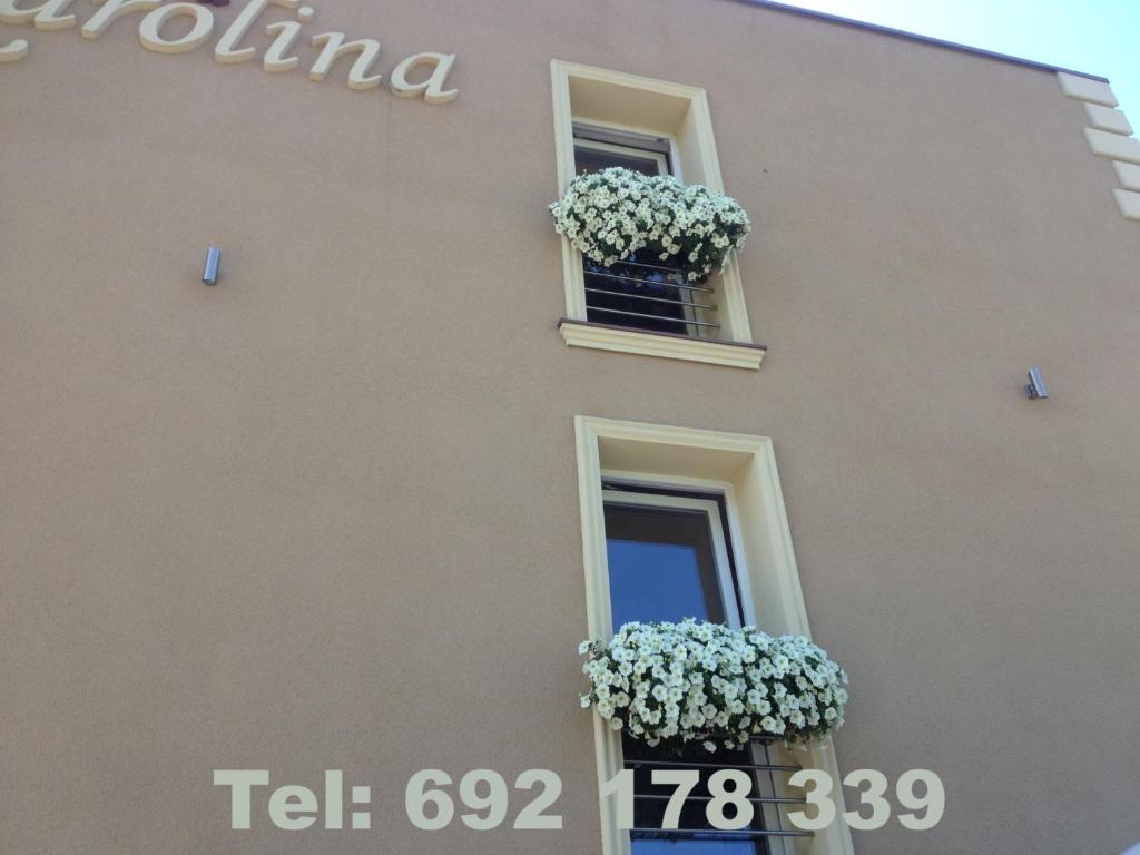 a building with two windows with flower boxes on it at Villa Karolina in Mielno