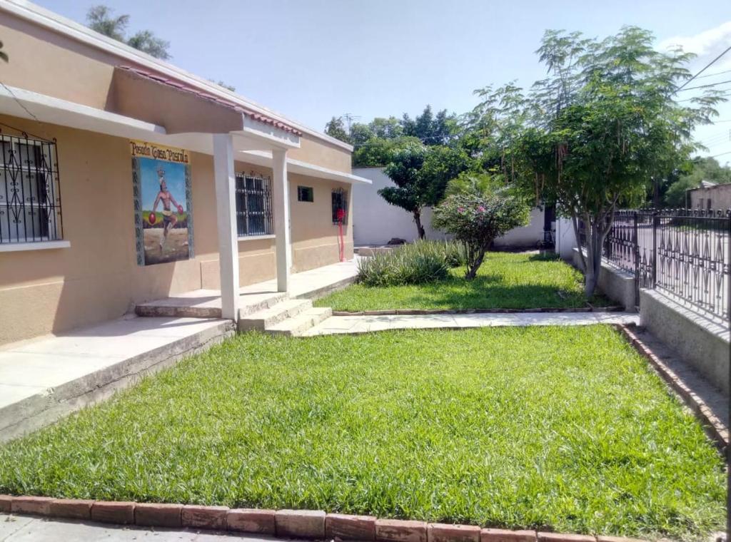 une maison avec une pelouse verte devant elle dans l'établissement Posada Casa Pascola, à El Fuerte