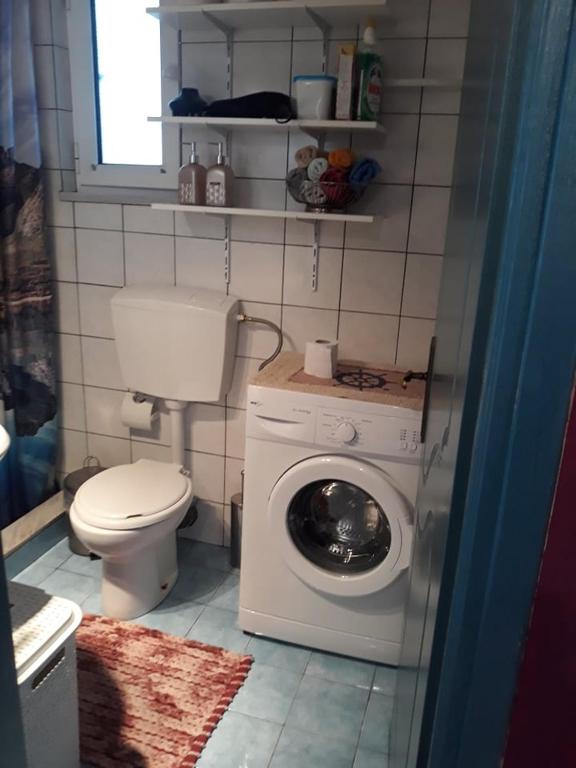 łazienka z toaletą i pralką w obiekcie The Best Offer w Prewezie