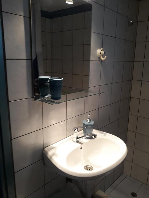 łazienka z białą umywalką i lustrem w obiekcie The Best Offer w Prewezie
