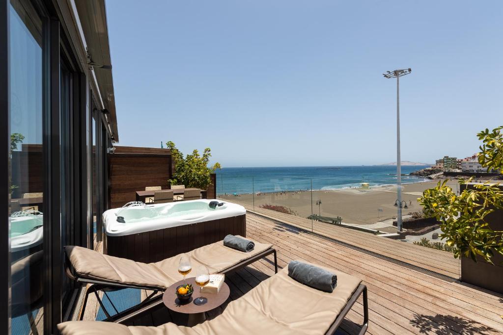 a balcony with a tub and two chairs and a table at La Marine in Melenara