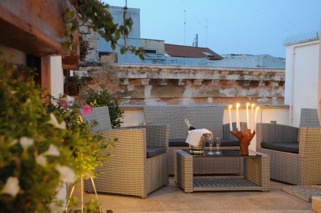eine Terrasse mit Korbstühlen und einem Tisch mit Kerzen in der Unterkunft B&B Vin e Va in Bari