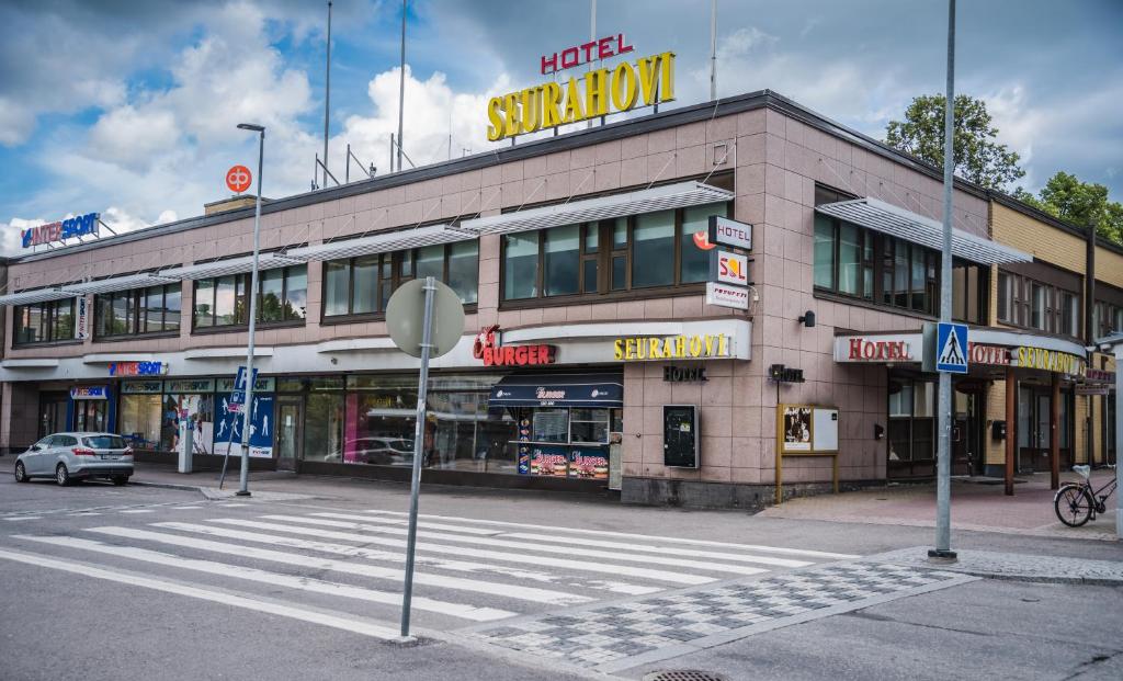 a building with a sign on the side of a street at Hotelli Seurahovi in Porvoo