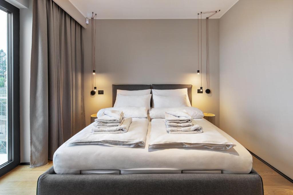 een slaapkamer met een bed met witte lakens en kussens bij FourRoomotel in Matulji