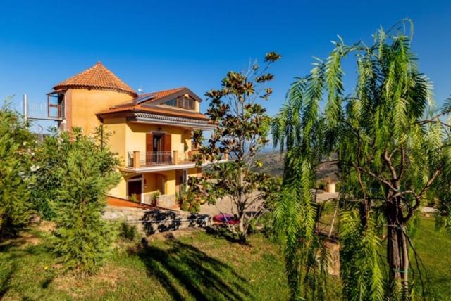 duży dom na szczycie wzgórza z drzewami w obiekcie Casa Vacanza Villa Aurora w mieście Laureana Cilento