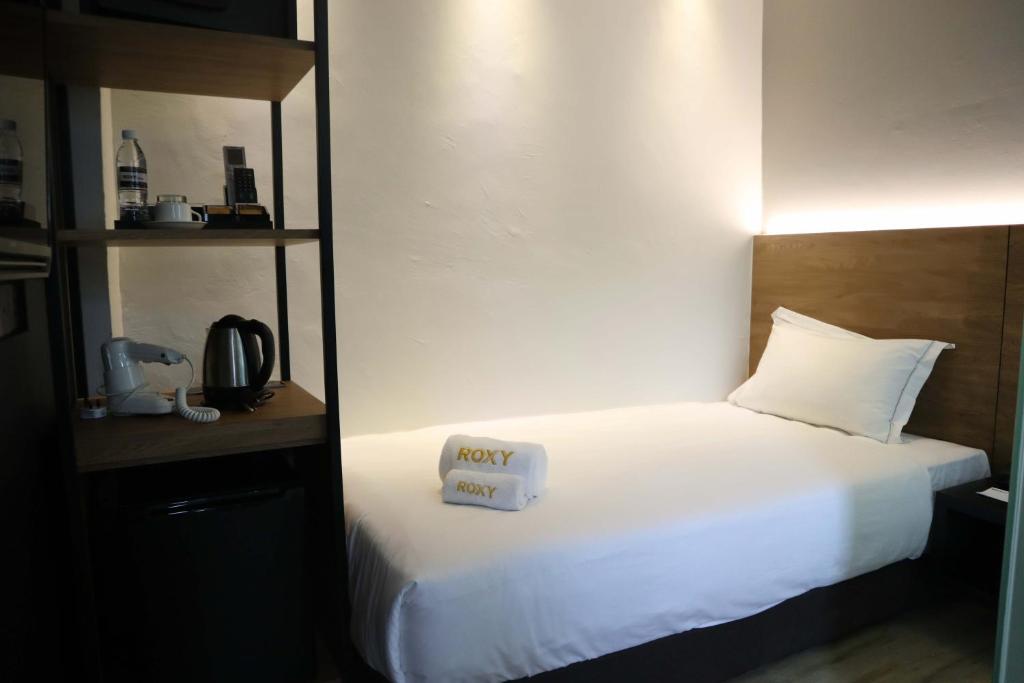 Postel nebo postele na pokoji v ubytování Roxy Hotel Padungan