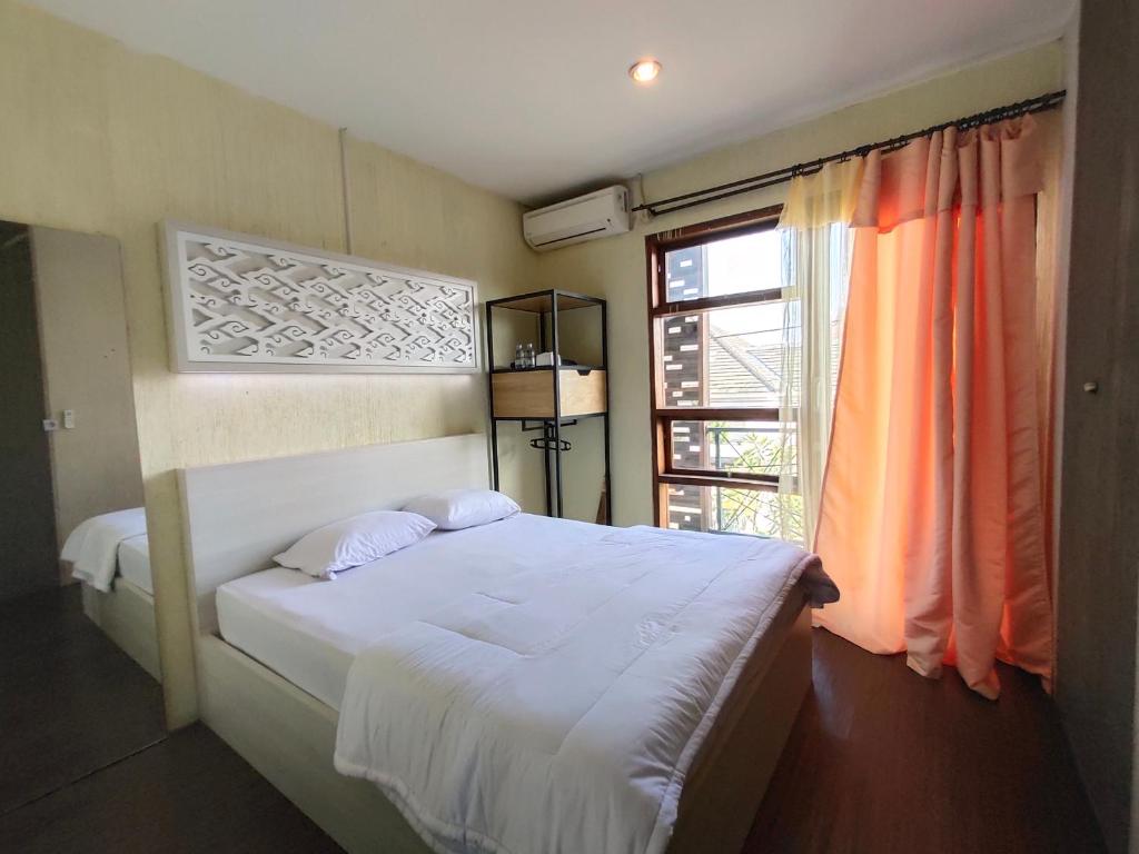 a bedroom with a white bed and a window at De Hanami Homestay @Sapphire in Cirebon