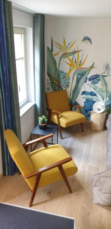 a living room with two chairs and a table at Caveau de l'ami Fritz in Ribeauvillé