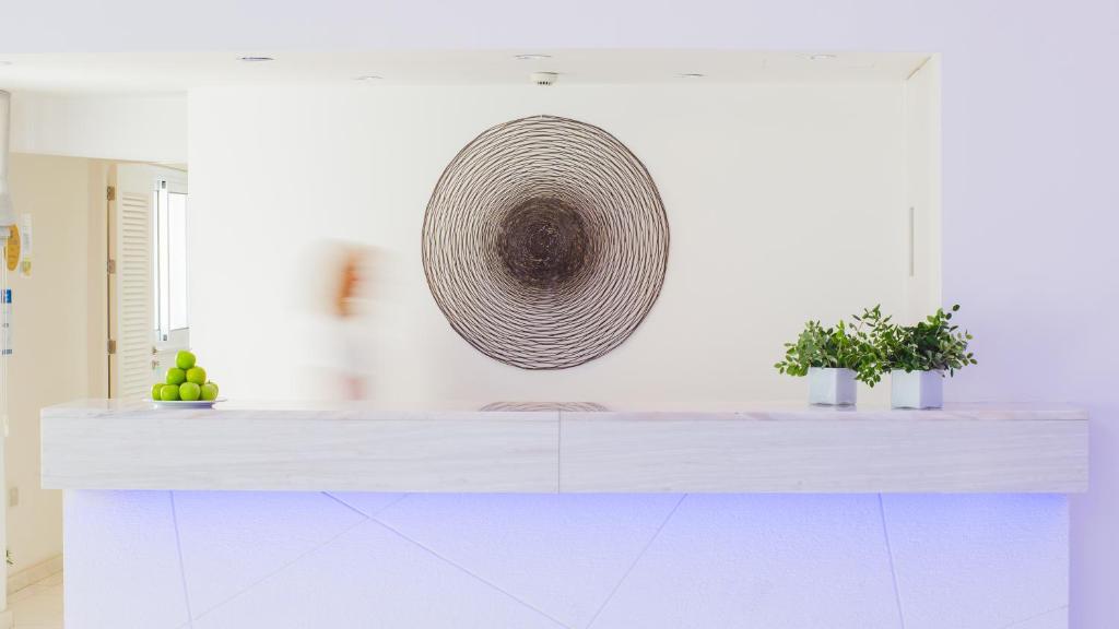 a kitchen with a white counter with a basket on the wall at Nissi Park Hotel in Ayia Napa