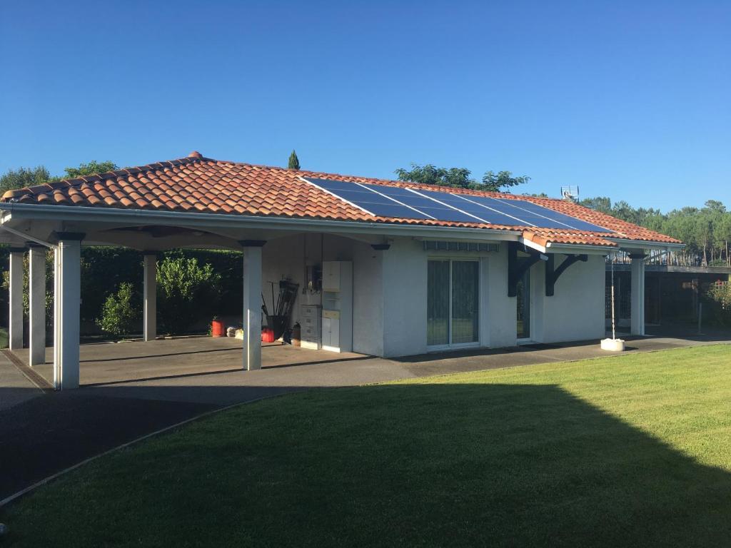 ein Haus mit einem Dach mit Sonnenkollektoren darauf in der Unterkunft L'Ostalòt in Saint-Vincent-de-Tyrosse