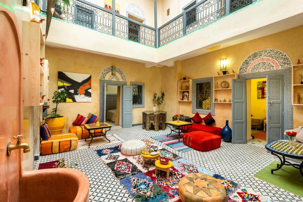 sala de estar con sofá rojo y alfombra en Riad Belko, en Marrakech