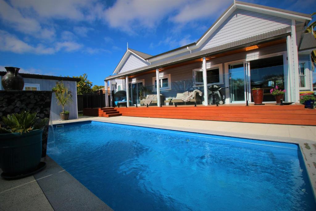 a house with a swimming pool in front of a house at AristaAir- Poppies Luxury Villa in Rotorua