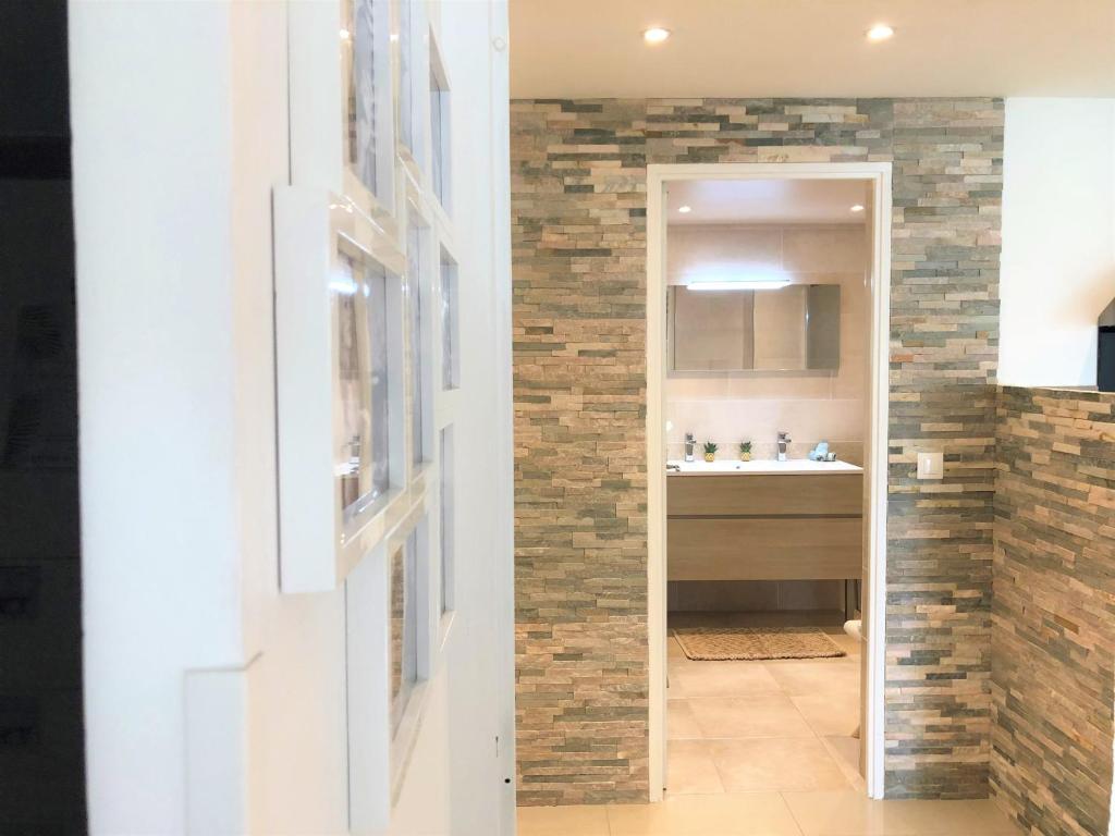 a bathroom with a brick wall and a sink at Appartement Cosy Calme Central-Terrasse Proche Palais in Cannes