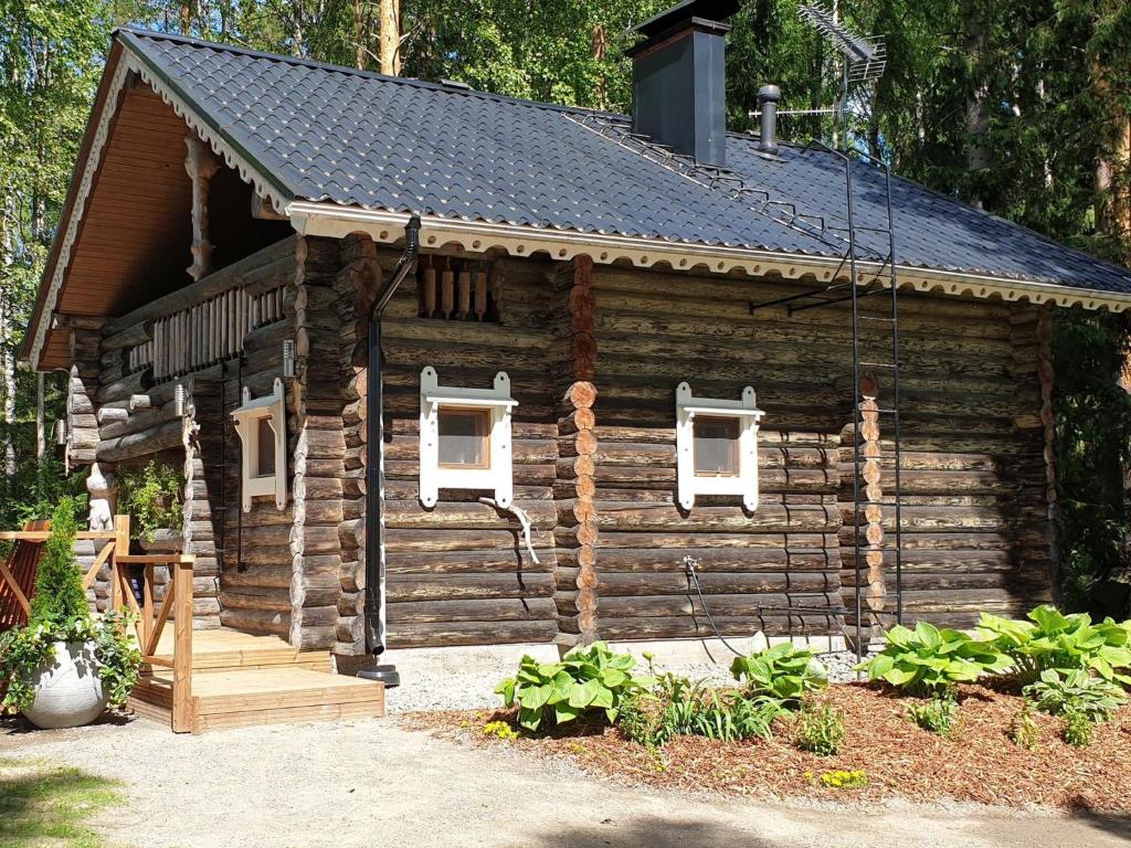 a log cabin with a porch and a roof at Holiday Home Matruusin majakka by Interhome in Onkamo