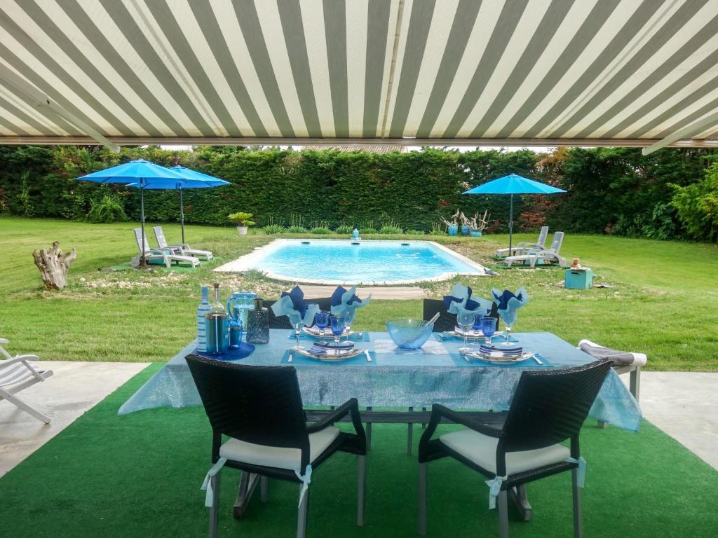 RognonasにあるHoliday Home Un petit coin de paradis by Interhomeの青いテーブル(椅子付)、プール