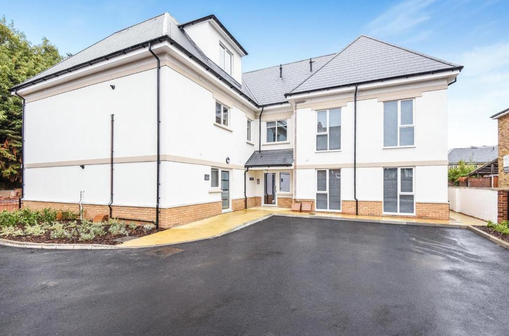 a large white house with a parking lot at Magna House in Egham