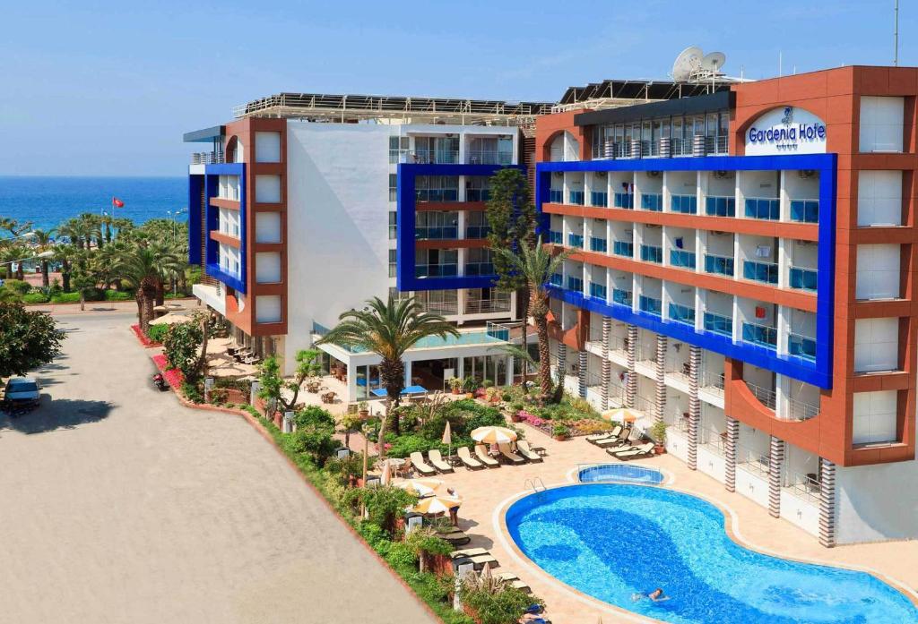 a hotel with a swimming pool next to a resort at Gardenia Hotel in Alanya