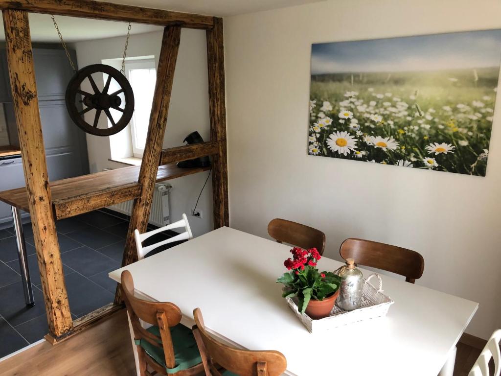 a dining room with a white table and chairs at Heckenstübchen in Simmerath