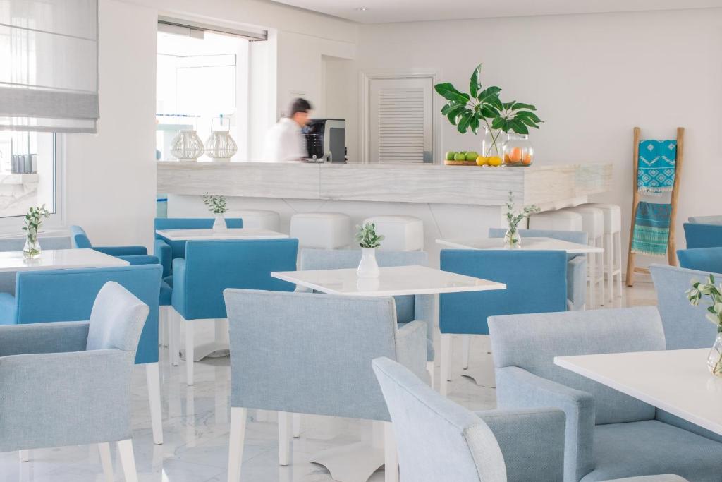 a restaurant with blue and white tables and chairs at Nissi Park Hotel in Ayia Napa