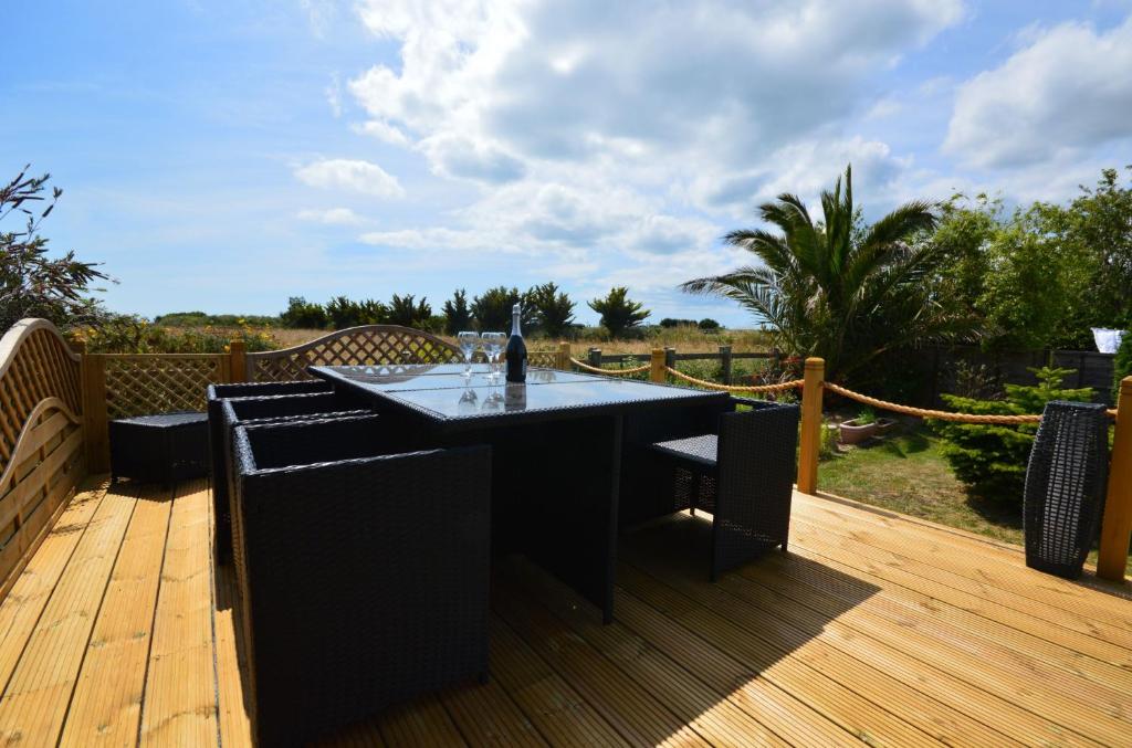 a black table and chairs on a wooden deck at Long Ledge in Bembridge
