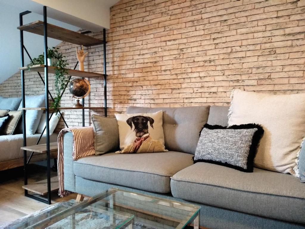 uma sala de estar com um sofá com um cão em Nature Rural- Collections em Berzosa del Lozoya