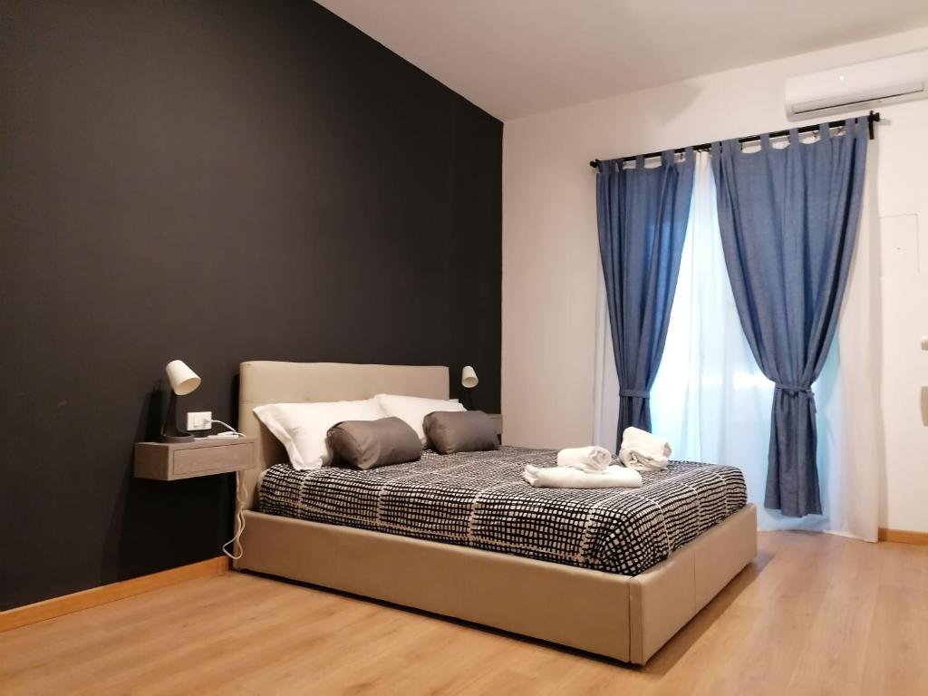 una camera da letto con letto e tende blu di Chroma Italy - Doctor House a Roma