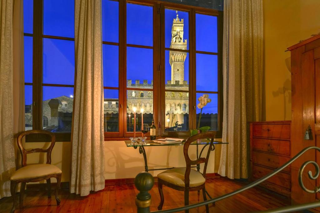 a room with a table and chairs in front of a window at Palazzo Uguccioni Apartments in Florence
