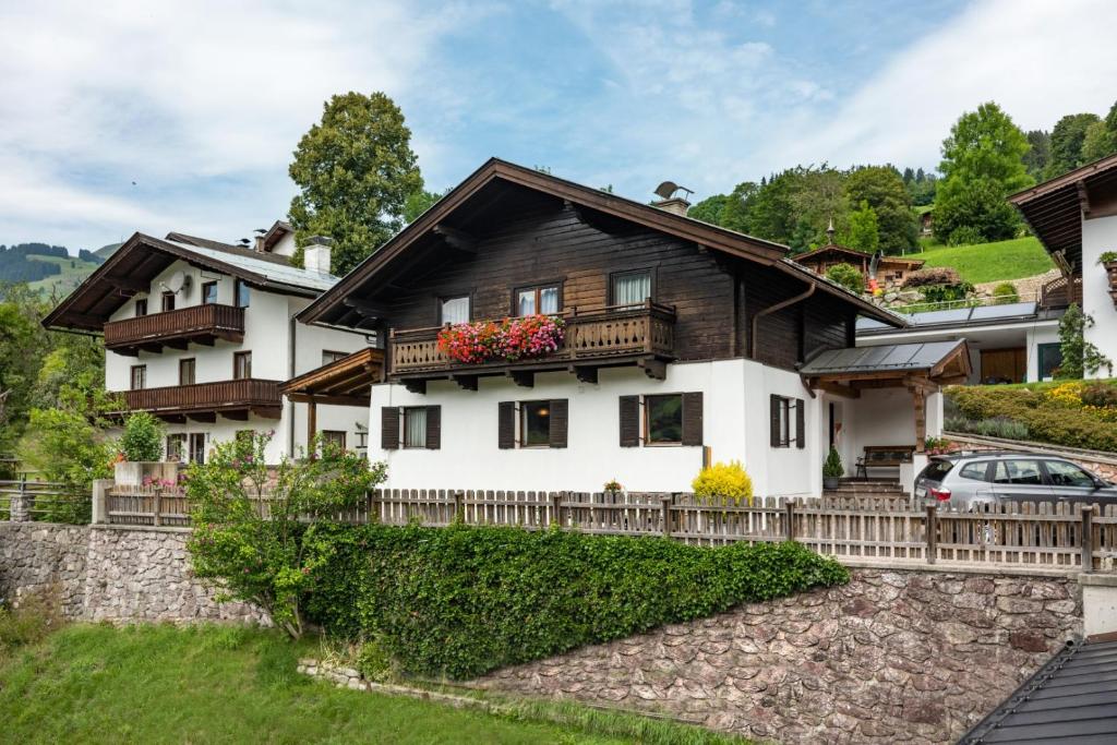 ein Haus in den Bergen mit einem Zaun in der Unterkunft Ferienhaus Bachler in Brixen im Thale