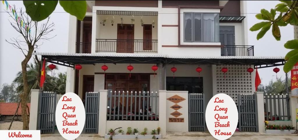 a house with red signs in front of it at Homstay Lac Long Quan in Tam Kỳ