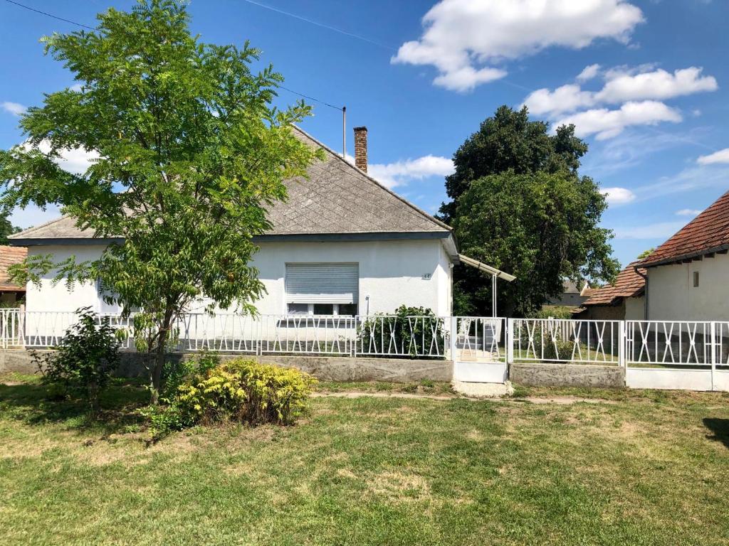 a white fence in front of a white house at Dancz Home in Dég