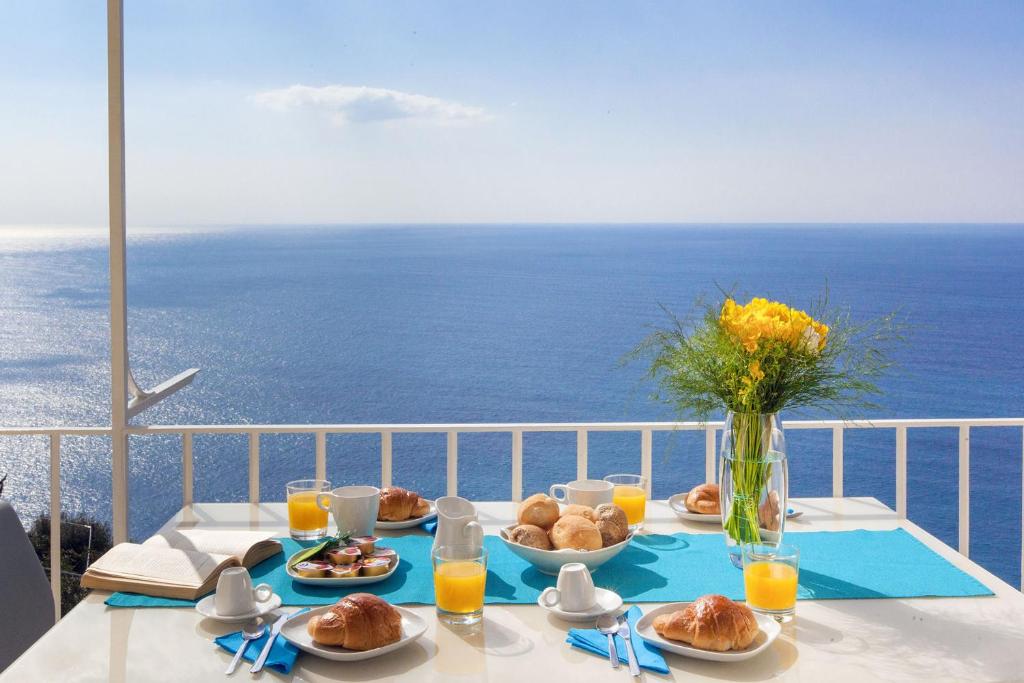 stół z jedzeniem i widokiem na ocean w obiekcie Amore Rentals - Villa Anna w mieście Positano