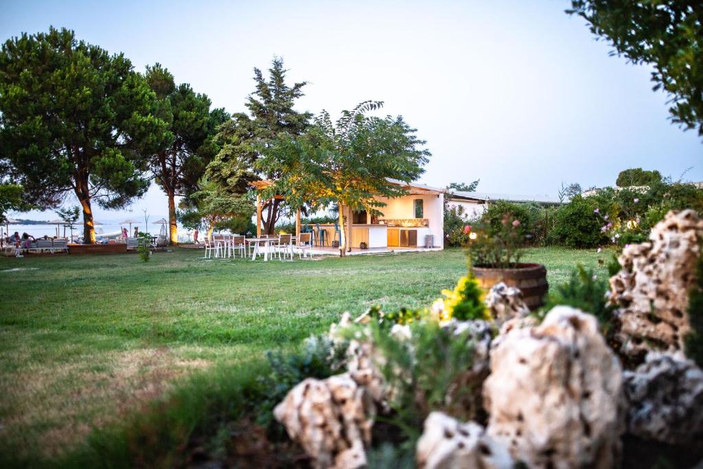 a house in a yard with flowers in the foreground at Kokkinos in Vourvourou