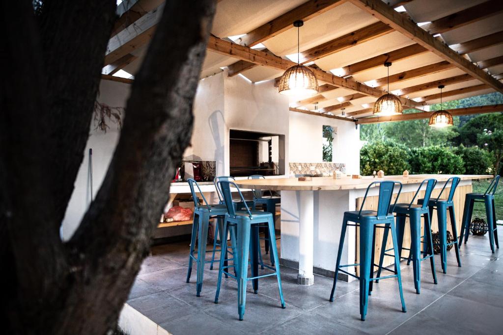 a kitchen with blue stools and a large table at Kokkinos in Vourvourou
