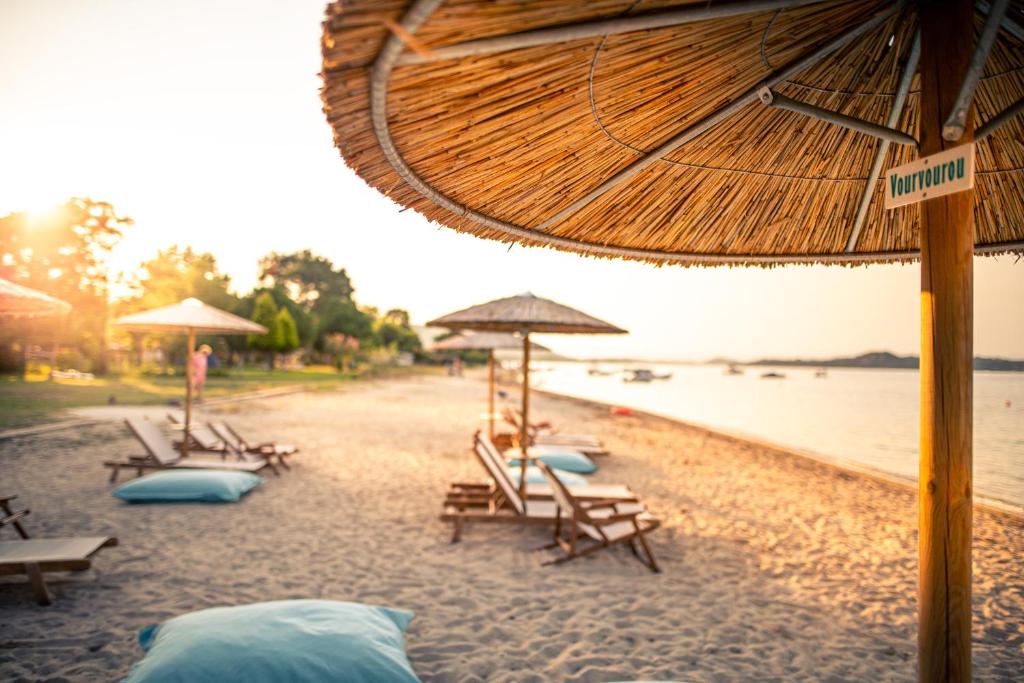 a group of chairs and umbrellas on a beach at Kokkinos in Vourvourou
