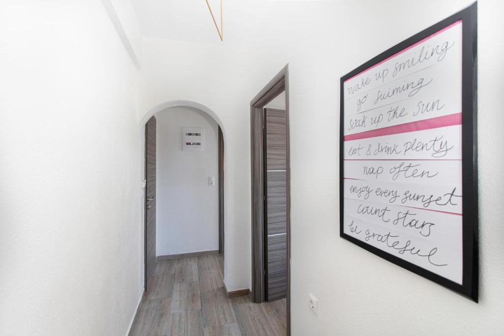a hallway with a painting on the wall and a mirror at Kokkinos in Vourvourou