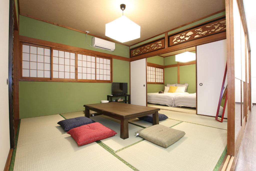 a room with a bedroom with a bed and a table at Sakurajima Parkside House B in Osaka