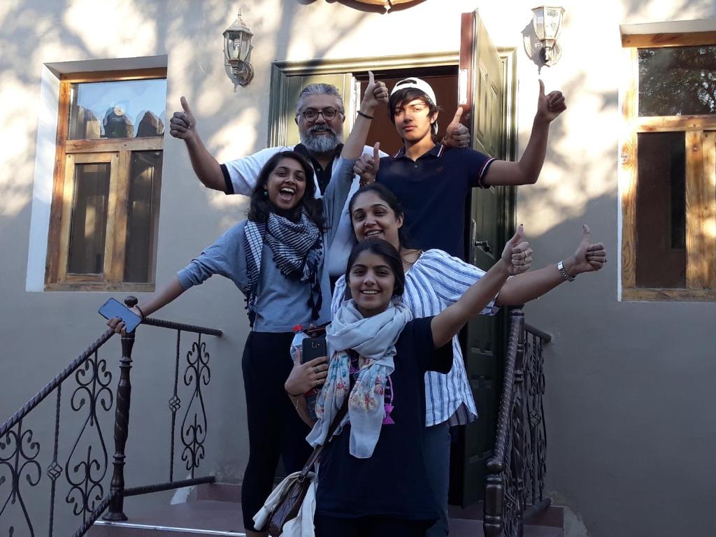 a group of people standing on the stairs of a house at Guest House Orzu in Khiva