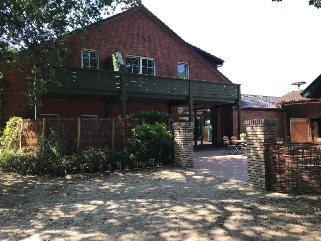 ein Backsteinhaus mit Balkon darüber in der Unterkunft Landcafe Neumann in Bad Zwischenahn