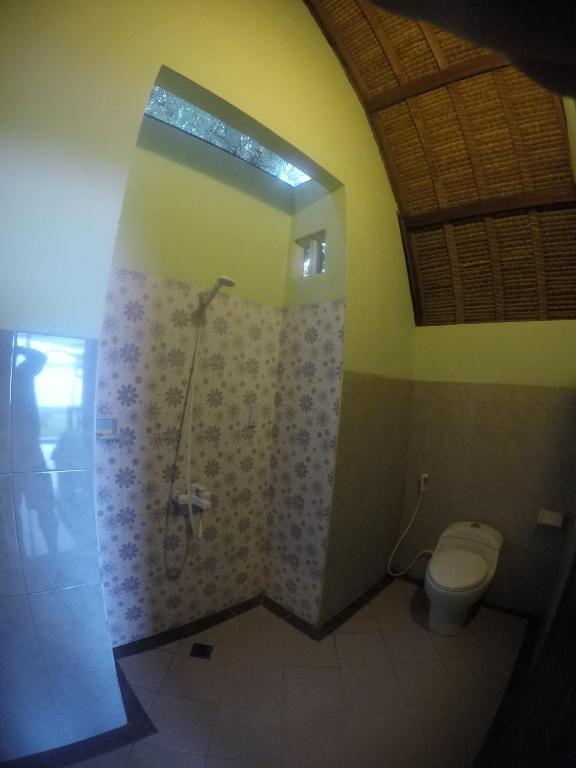 a bathroom with a shower and a toilet at Krisna Bungalows and Restaurant in Sekotong