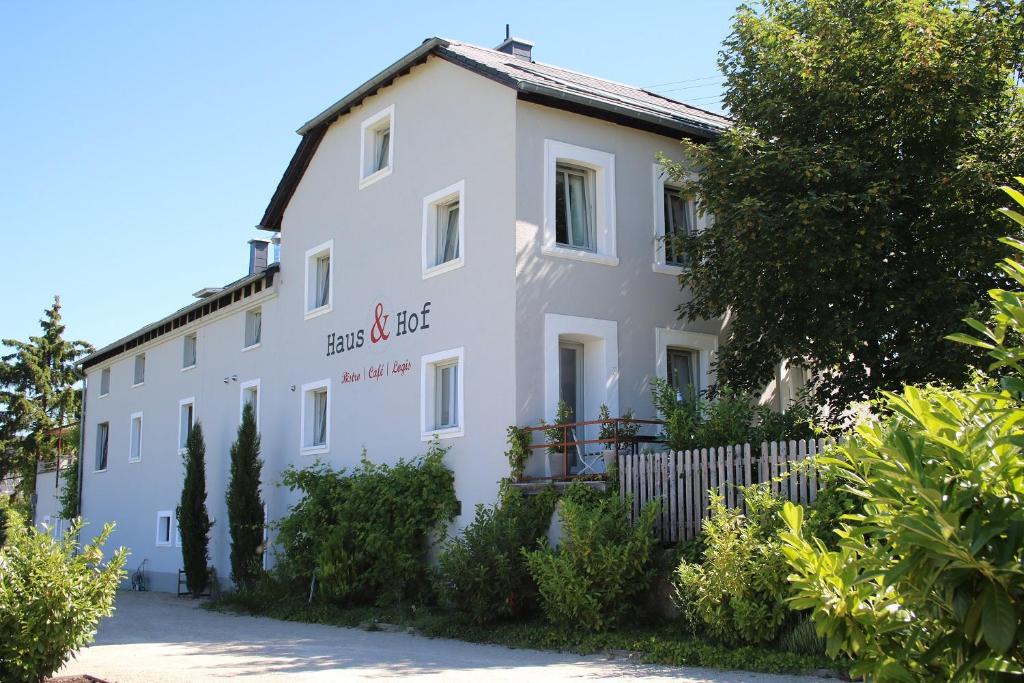 a white building with a fence in front of it at Haus & Hof Guest House in Perl