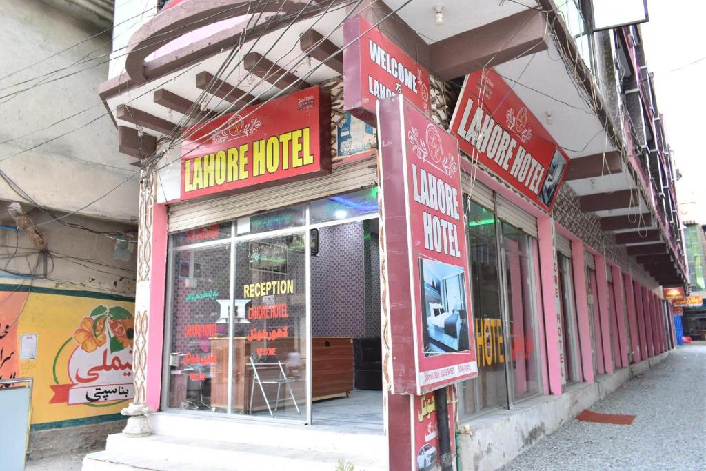 una tienda con letreros al lado de un edificio en Lahore Hotel, en Swat