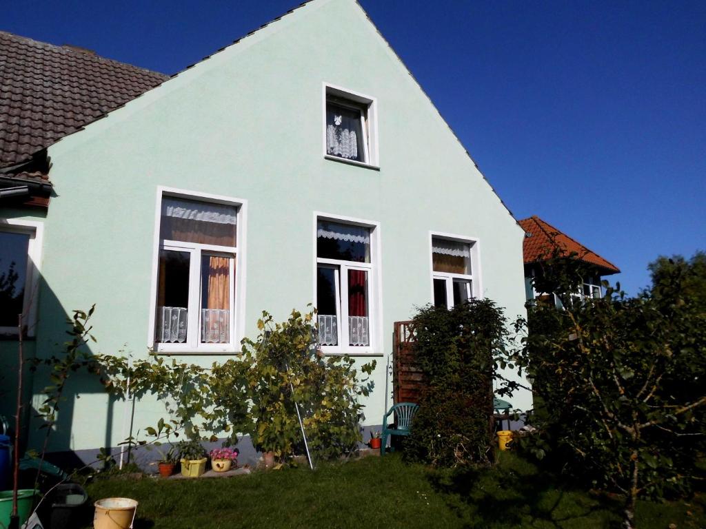 uma casa branca com quatro janelas num quintal em Haus Ebel em Putgarten