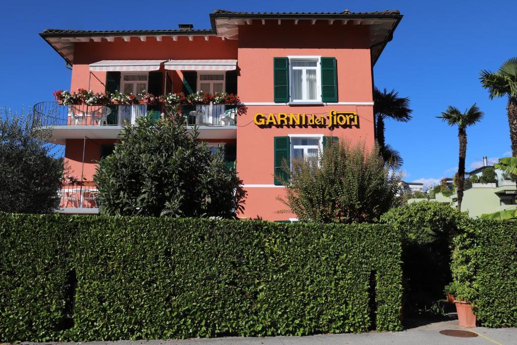 um edifício cor-de-rosa com um sinal para um restaurante em Hotel Garni dei fiori em Ascona